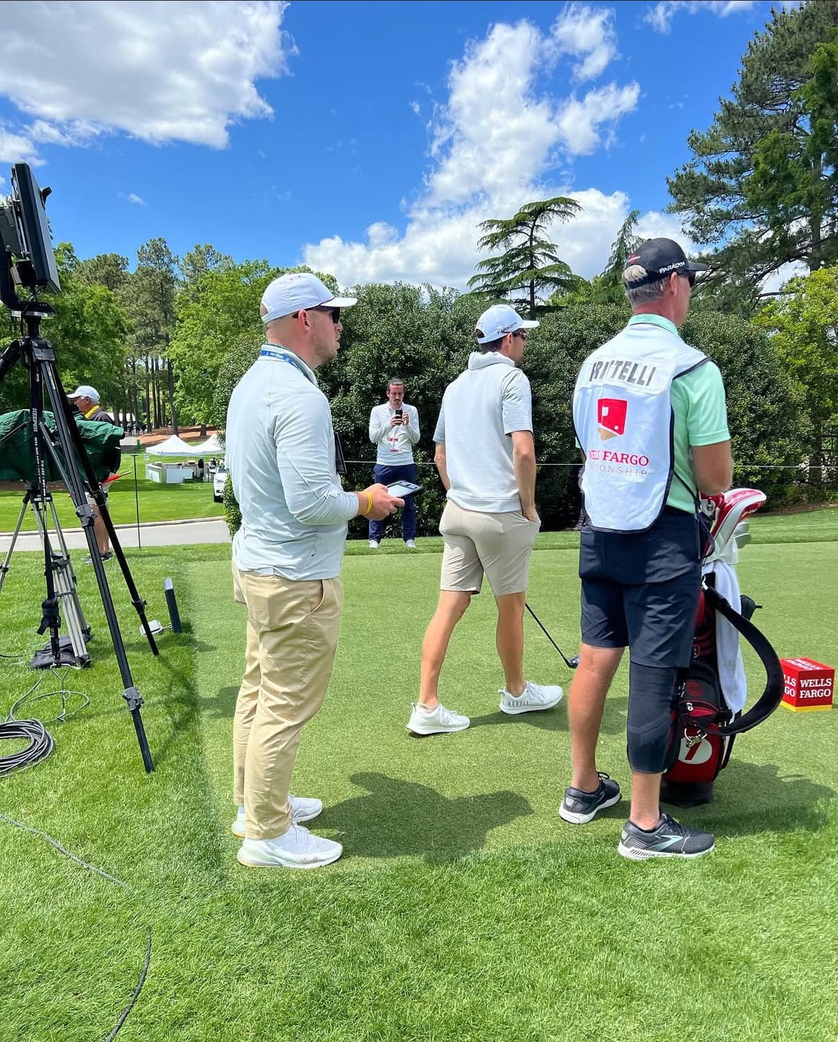 Cory Jez with a player and caddie on the course at a Tour event